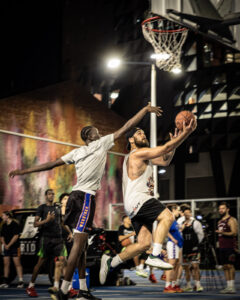 Basketball player making a layup during a night game