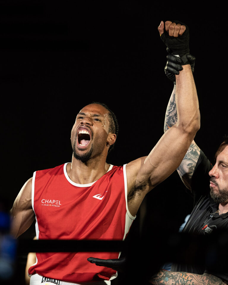Boxer celebrating victory in the ring after a fight night bout. Sports photography portfolio featuring Melbourne athletes.