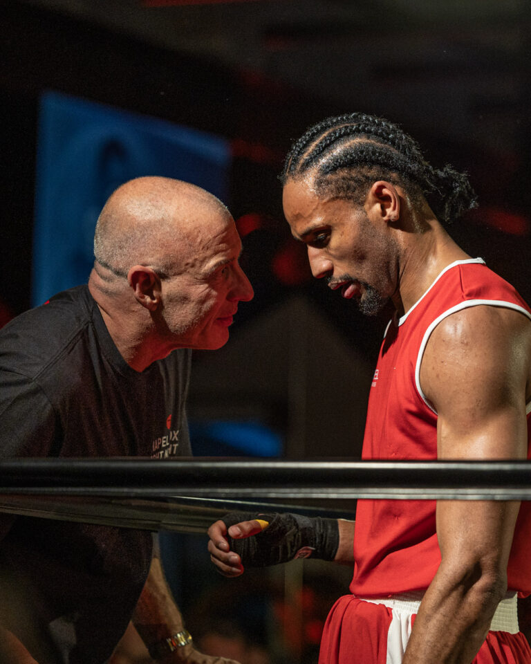 Boxing coach and athlete reflecting together after a fight