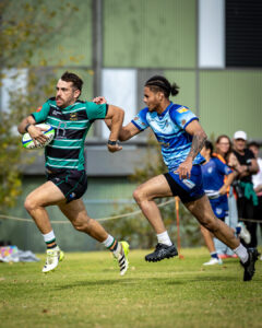 A Power House Rugby player sprints downfield while being chased by a defender during a rugby union match.